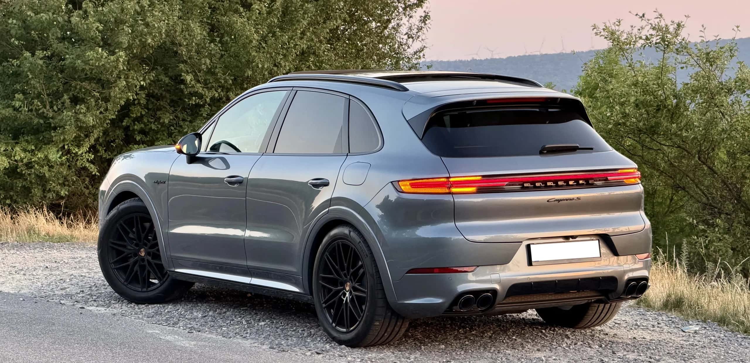 Porsche Cayenne S parked on a country road at golden hour
